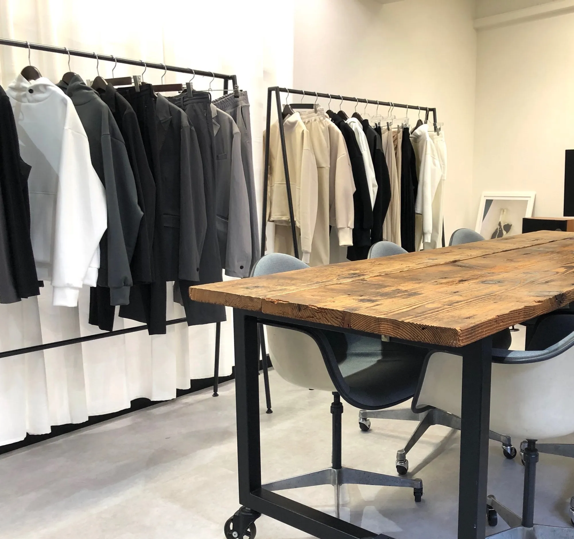 DSSR のオフィス。服が掛かったラックと木の作業テーブル